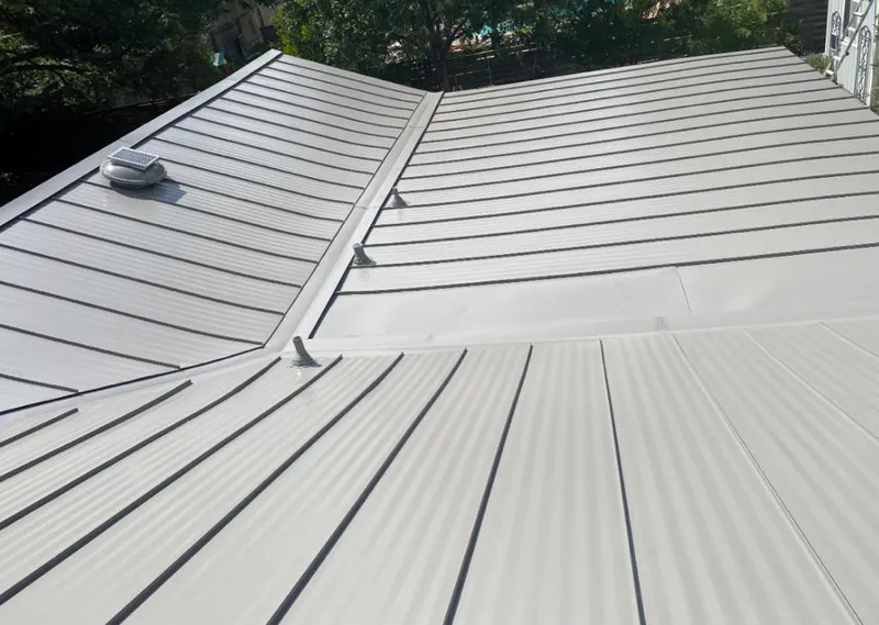 Solar attic fan installed on a metal roof for Roof Ventilation in Seward